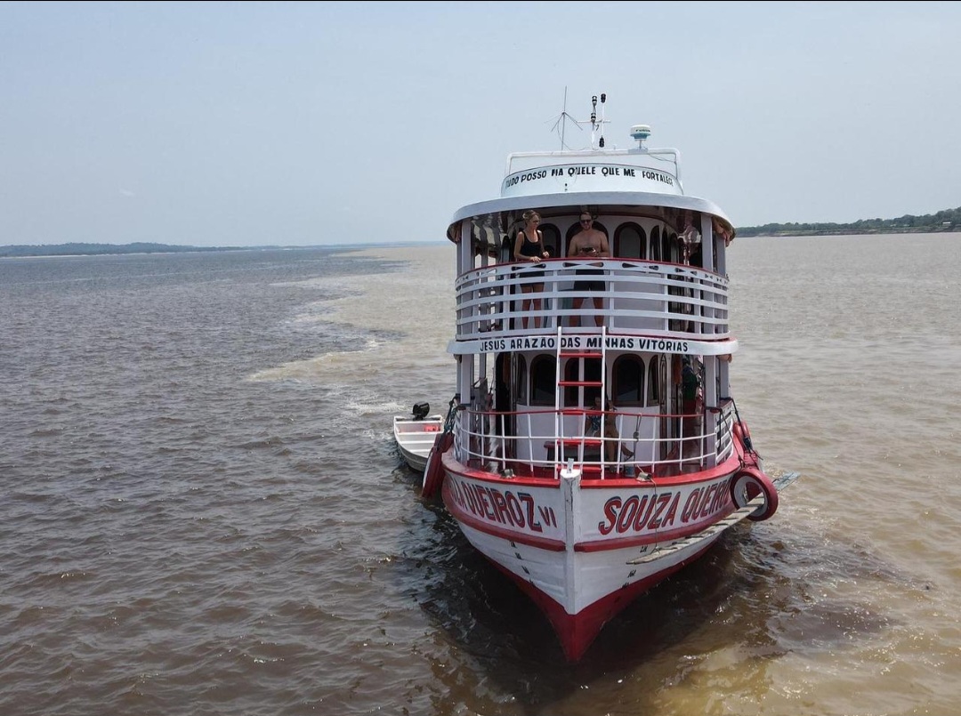 Barco navegando pelas águas da Amazônia ao entardecer